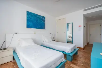 two beds in a room with white walls at Alto da Lua in Bordeira