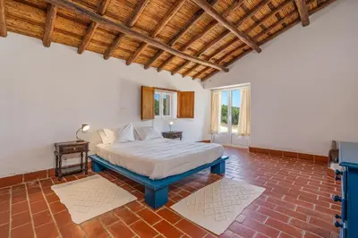 a bedroom with a bed and a wooden ceiling at Casa da Lua in Aljezur