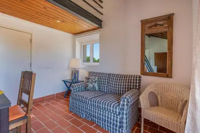 a living room with a couch and a mirror at Casa da Lua in Aljezur