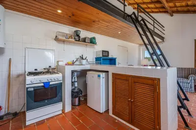 a kitchen with a stove and a refrigerator at Casa da Lua in Aljezur