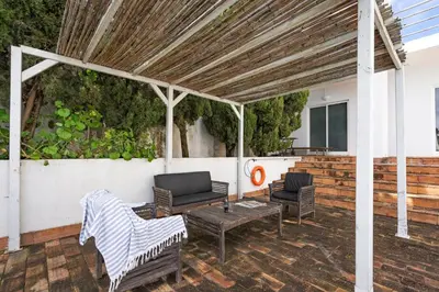 a patio with two chairs and a table at Casa da Lua in Aljezur