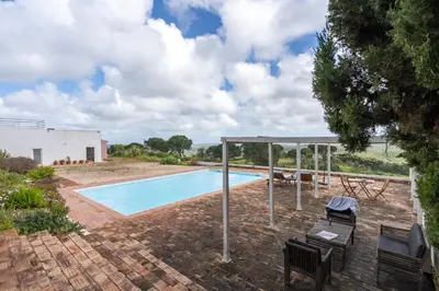 a swimming pool in a yard with a pavilion at Casa da Lua in Aljezur