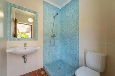 a bathroom with a shower and a toilet and a sink at Villa Azure Family & Surf Escape in Aljezur