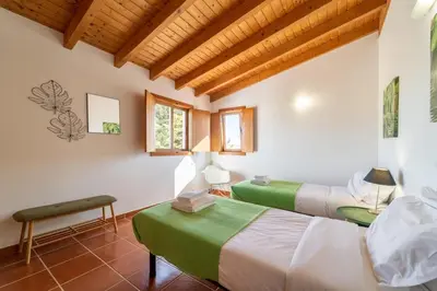 two beds in a room with wooden ceilings at Villa Azure Family & Surf Escape in Aljezur