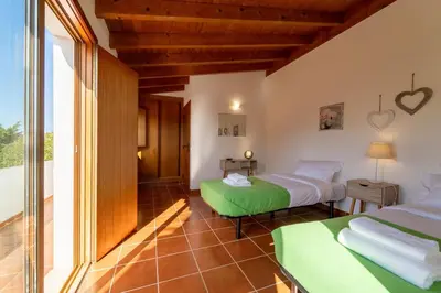 two beds in a room with a window at Villa Azure Family & Surf Escape in Aljezur