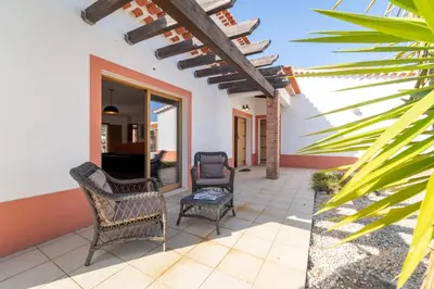 a patio with two chairs and a table at Villa Azure Family & Surf Escape in Aljezur