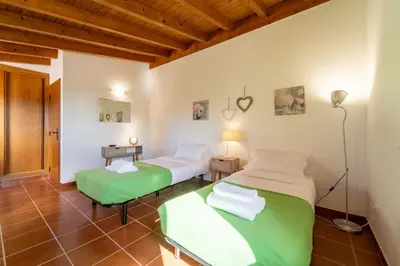 two twin beds in a room with wooden ceilings at Villa Azure Family & Surf Escape in Aljezur
