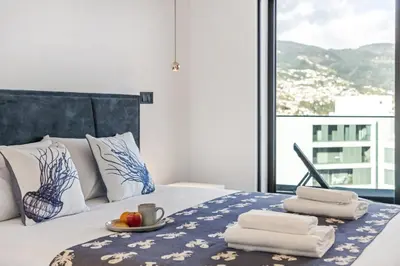 a bed with towels and a plate of fruit on it at Apartment Bay View - By WeHost in Funchal