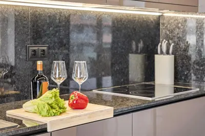 a kitchen with two wine glasses and a cutting board at Apartment Bay View - By WeHost in Funchal