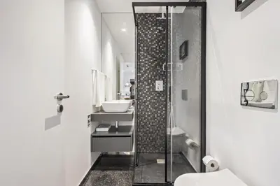 a bathroom with a glass shower and a sink at Apartment Bay View - By WeHost in Funchal