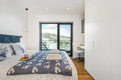 a bedroom with a bed and a desk and a window at Apartment Bay View - By WeHost in Funchal