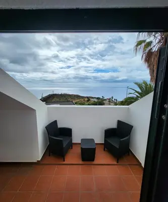 a balcony with two chairs and a view of the ocean at The Garajau Views in Caniço