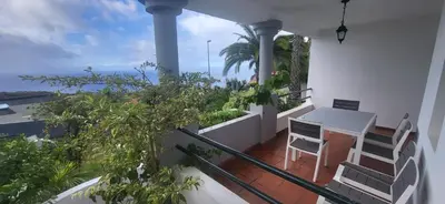 a balcony with a table and chairs on a balcony at The Garajau Views in Caniço