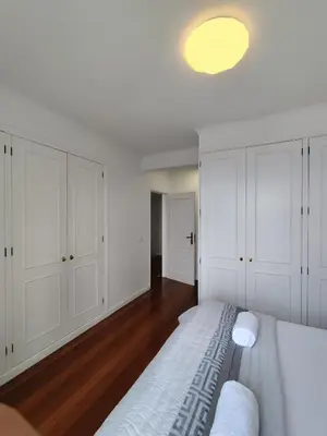 a white bedroom with white cabinets and a bed at The Garajau Views in Caniço