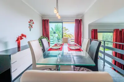 a dining room with a long glass table and chairs at Rosa Villa Porto Santo by YOUR KEY in Porto Santo