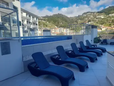 a bedroom with a large bed with two lamps at Art House Madeira I in Caniço