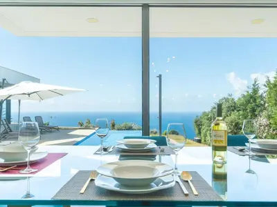 a dining table with a view of the ocean at Villa Primavera by Atlantic Holiday in Calheta