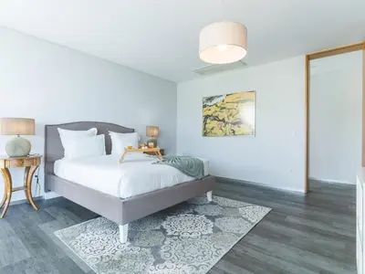 a white bedroom with a bed and a table at Villa Primavera by Atlantic Holiday in Calheta