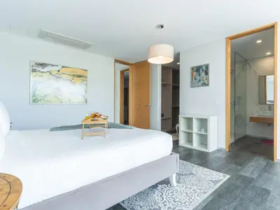 a white bedroom with a large bed and a mirror at Villa Primavera by Atlantic Holiday in Calheta
