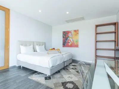 a white bedroom with a bed and a glass floor at Villa Primavera by Atlantic Holiday in Calheta