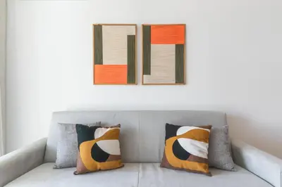 a couch with three pillows and a picture on the wall at Acqua The Finnest by Atlantic Holiday in Funchal