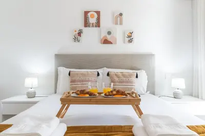 a breakfast tray on a bed with two glasses of orange juice at Acqua The Finnest by Atlantic Holiday in Funchal