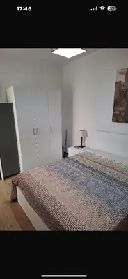a bedroom with a bed and a table with a lamp at House Dino & Telma in Machico