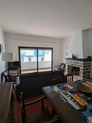 a living room with a couch and a fireplace at Casa Margarida in Vila do Bispo