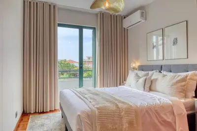 a bedroom with a large bed and a large window at Refúgio no Funchal, a Home in Madeira in Funchal