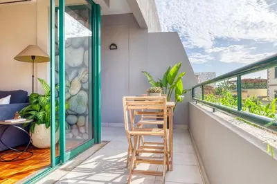 a balcony with a wooden stool and a table on it at Refúgio no Funchal, a Home in Madeira in Funchal