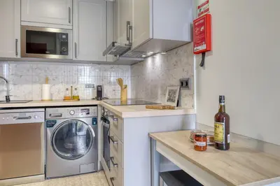 a kitchen with a washing machine and a washer at Refúgio no Funchal, a Home in Madeira in Funchal