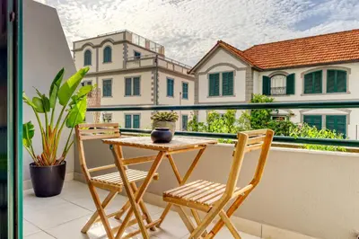 a balcony with a table and chairs on a balcony at Refúgio no Funchal, a Home in Madeira in Funchal