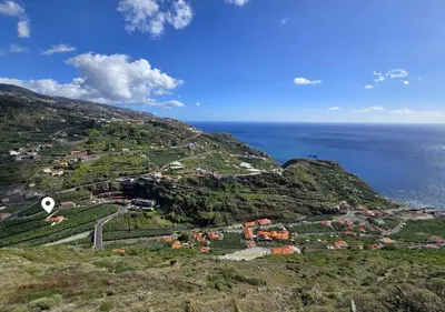 an aerial view of a village on a hill next to the ocean at Banana Lovers - Farm View in Ribeira Brava