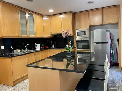a kitchen with wooden cabinets and a black counter top at Funchal Center Apartment in Funchal