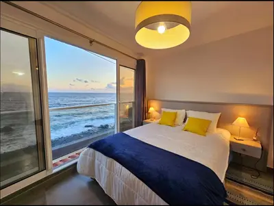 a bedroom with a bed with a view of the ocean at Ocean view in Paul do Mar