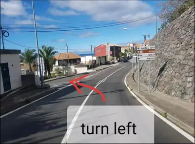 a street with a turn left sign on the road at Ocean view in Paul do Mar