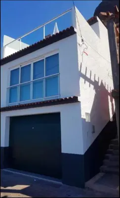 a building with a garage with a large door at Ocean view in Paul do Mar