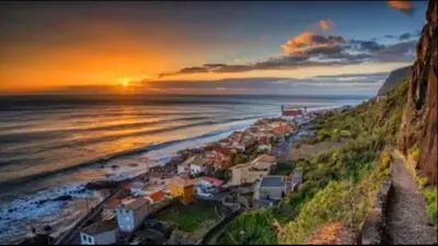 a view of a beach at sunset with the ocean at Ocean view in Paul do Mar