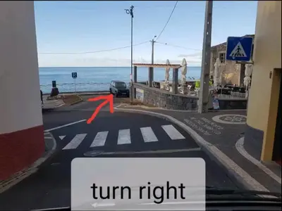 a turn right sign on a road with the ocean at Ocean view in Paul do Mar