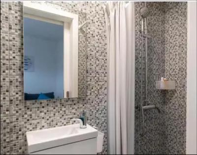 a bathroom with a sink and a mirror and a shower at Ocean view in Paul do Mar