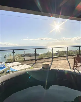 two blue chairs and a bed on a balcony at Lido ocean front penthouse in Funchal