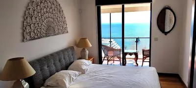 a deck with a hot tub and chairs on a patio at Lido ocean front penthouse in Funchal