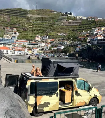 a woman sitting on the roof of a camper van at Geko camper in Funchal