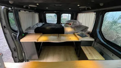 a camper van with a bed and tables in it at Geko camper in Funchal