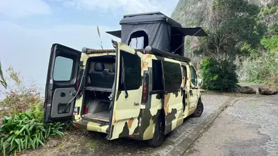 a camo van with a camo tent on the back at Geko camper in Funchal