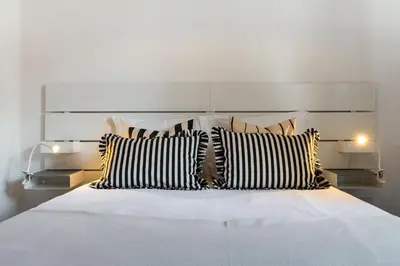 a bed with black and white pillows on it at Santiago House by An Island Apart in Funchal