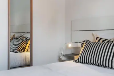 a bedroom with a mirror and a bed with striped pillows at Santiago House by An Island Apart in Funchal