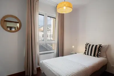 a bedroom with a bed with a window and a mirror at Santiago House by An Island Apart in Funchal