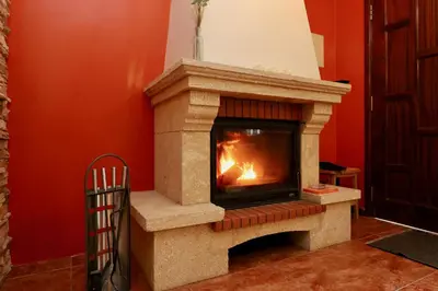 a stone fireplace in a room with a red wall at Villa Rose by AnaLodges in Senhora do Rosário