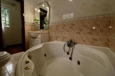 a white bath tub in a bathroom with a toilet at Villa Rose by AnaLodges in Senhora do Rosário
